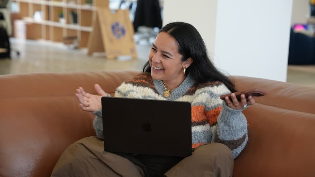 A Gumlooper laughing on a call from the office lounge couch